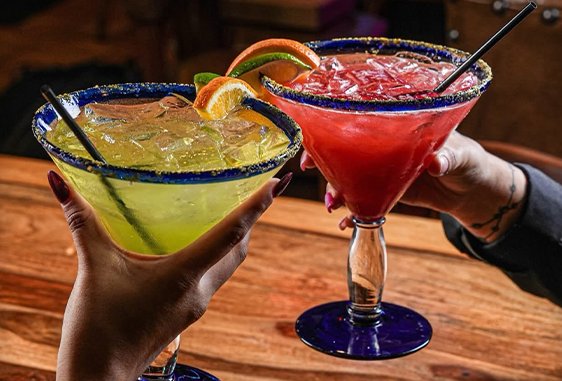 Two margaritas raised in a toast